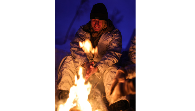 US Marines warm themselves by a fire near Setermoen.