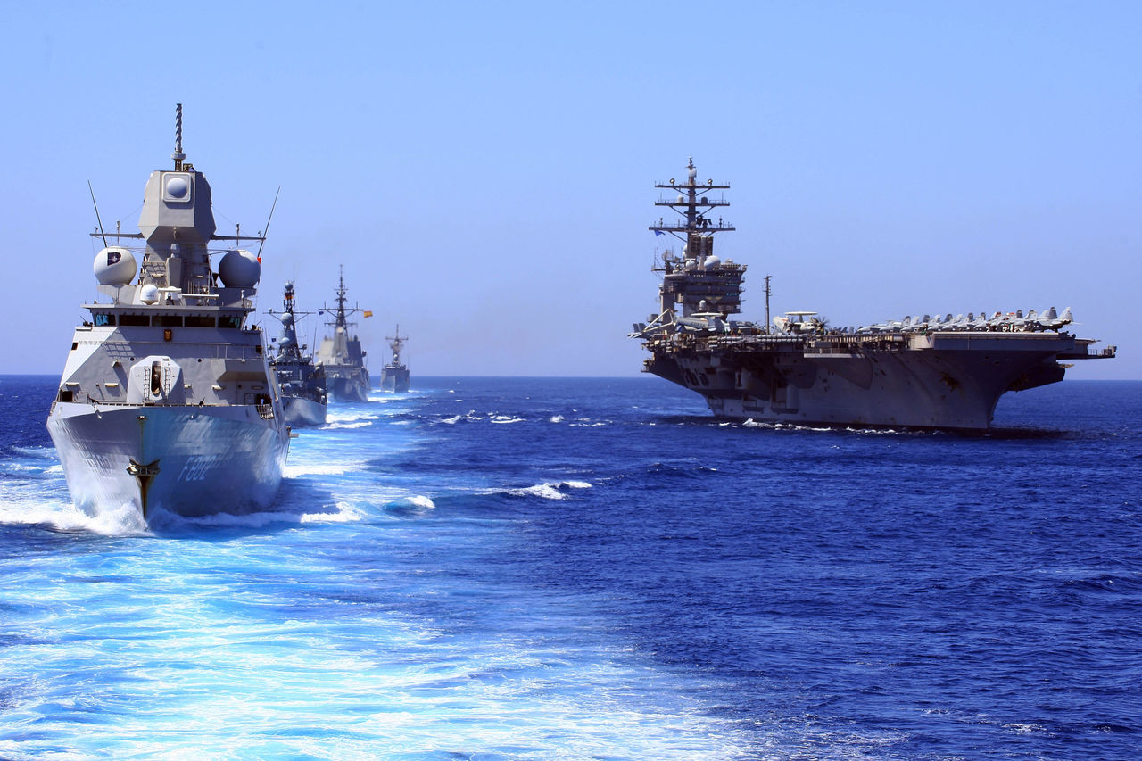 NATO dignitaries and guests on board USS Eisenhower (right) watched as SNMG1 frigates conducted a sailpast. The frigat in the foreground  is the HNLMS De Zeven Provinciën (Netherlands), followed by FGS Emden (Germany),  USS Halyburton (United States of America), ESPS Blas de Lezo (Spain). Photographs are made from the flagship PRS Corte Real (Portugal).
