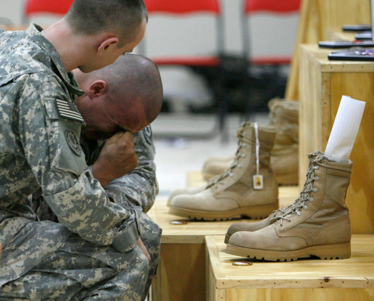 A U.S. soldier (R) of 1st Squadron, 2nd Stryker Cavalry Regiment, cries during a memorial service for three fellow soldiers who were killed during clashes last March 25 and April 7, at a military camp in Baghdad April 16, 2008.  REUTERS/Erik de Castro  (IRAQ)