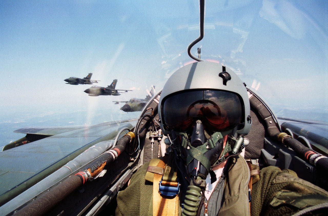 Pilot im Cockpit des Mehrzweckkampfflugzeugs Tornado. Im Hintergrund noch drei weitere Maschinen des gleichen Typs im Formationsflug. 1328528
