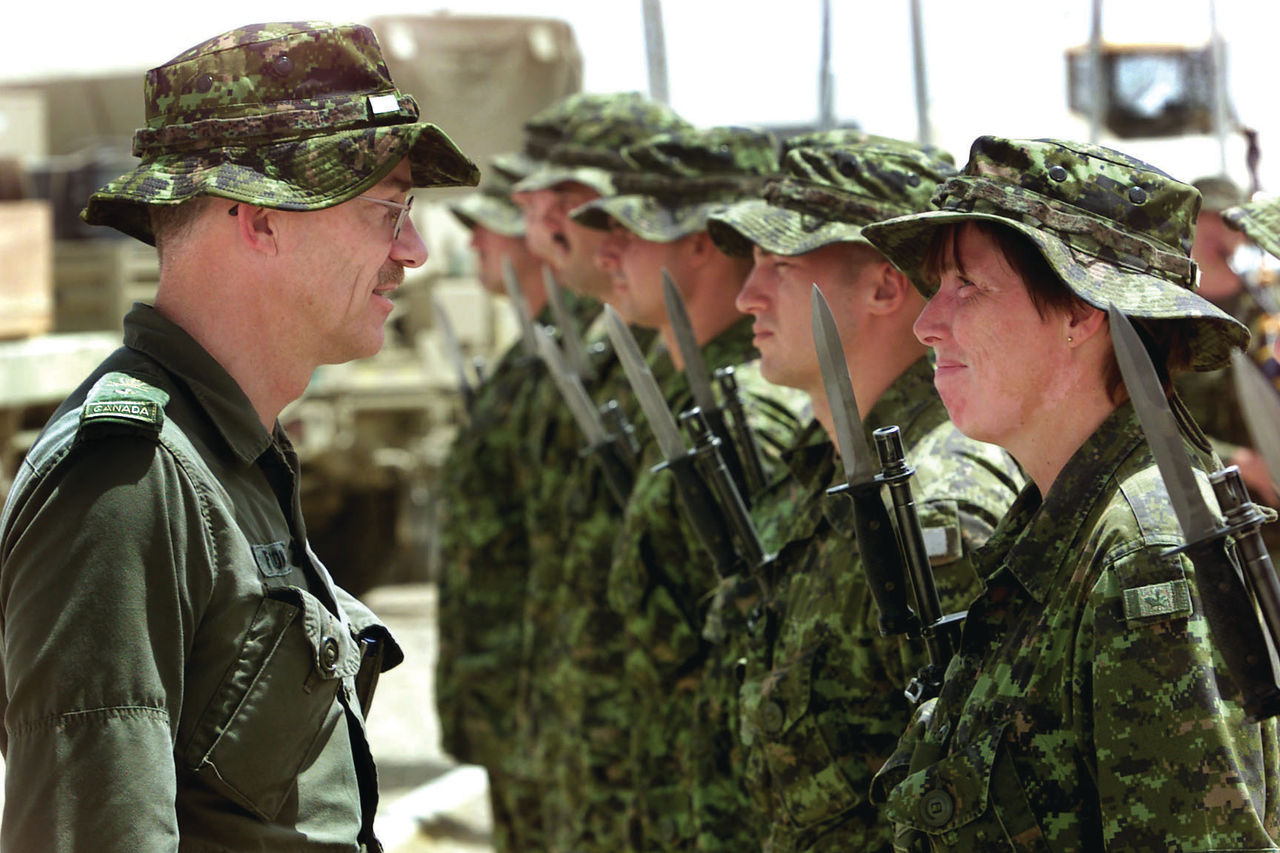 English/Anglais<br>
AP2002-5445<br>
May 14, 2002<br>
Kandahar, Afghanistan<br><br>
Brigadier-General Ivan Fenton, commander of Land Force Western Area, talks to a female member of the quarter guard mounted at Kandahar International Airport by the 3rd Battalion, Princess Patriciaís Canadian Light Infantry (3 PPCLI) Battle Group. BGen Fenton is visiting Kandahar to tour the airfield, where the 3 PPCLI Battle Group is based, and to talk with Canadian Forces members serving there. The 3 PPCLI Battle Group is deployed in Afghanistan on Operation APOLLO, Canadaís military contribution to the international campaign against terrorism.<br>
Photo by Cpl Lou Penney, 3 PPCLI Battle Group
<br><br>
FranÁais/French<br>
AP2002-5445<br>
Le 14 mai 2002 <br>
Kandahar (Afghanistan)<br><br>
Le brigadier-gÈnÈral Ivan Fenton, commandant du Secteur de líOuest de la Force terrestre, parle ‡ un membre fÈminin du corps de garde montÈ ‡ líAÈroport international de Kandahar par le Groupement tactique du 3e Bataillon, Princess Patriciaís Canadian Light Infantry (3 PPCLI). Le bgÈn Fenton visite Kandahar pour une tournÈe du terrain díaviation, o˘ le Groupement tactique du 3 PPCLI est basÈ, et pour parler aux membres des Forces canadiennes qui y servent. Le Groupement tactique du 3 PPCLI est dÈployÈ en Afghanistan dans le cadre de líopÈration Apollo, la participation militaire du Canada ‡ la campagne internationale contre le terrorisme.<br>
Photo par le cpl Lou Penney, Groupement tactique du 3 PPCLI
