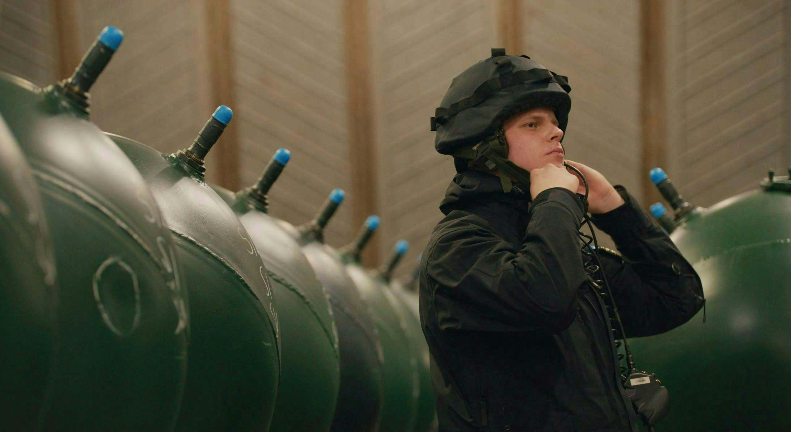 A Finnish Navy crew member beside a row of dummy mines during exercise Freezing Winds 24. Turku, Finland, November 2024.