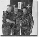 Hand-over: General Klaus Reinhardt (left) shakes hands with Lieutenant-General Juan Ortuo (right), in the presence of then SACEUR, General Wesley Clark. (NATO photo - 32Kb)
)