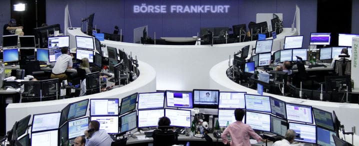  Traders are pictured at their desks in front of the DAX board at the Frankfurt stock exchange July 7, 2015. © Reuters
