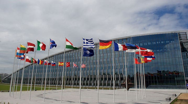 Les drapeaux des 29 pays membres de l'Alliance flottent au vent face au nouveau siège de l’OTAN – un symbole de la transformation de l'Organisation au XXIe siècle.
)