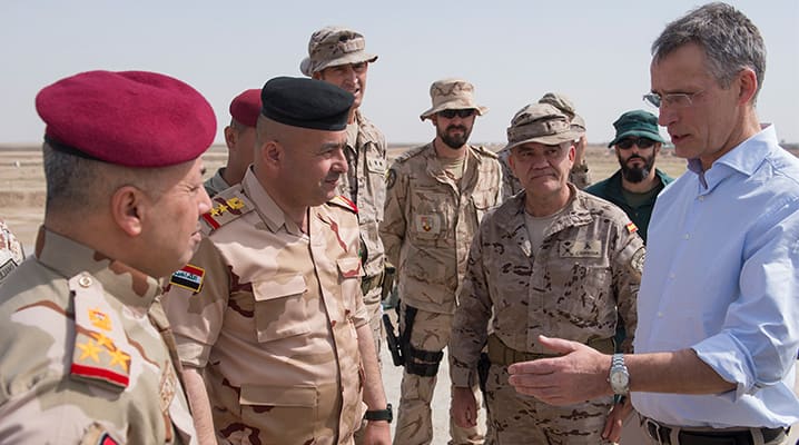 NATO Secretary General Jens Stoltenberg talks to NATO trainers and Iraqi troops during a visit to the NATO Training Camp in Iraq on 5 March 2018. Allied defence ministers agreed in February 2018 to start planning for a training mission to deepen NATO’s defence capacity building support for the country. © NATO
)