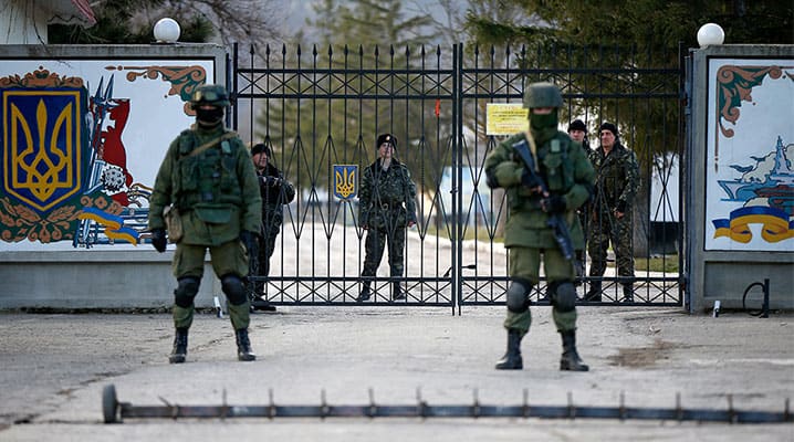 Russian special forces troops in unmarked uniforms stand guard at a Ukrainian military base near Simferopol, which had been surrounded during Russia’s illegal annexation of Crimea in March 2014. © Sovereign Ukraine
)