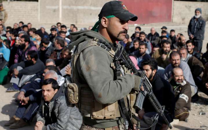  Agent wywiadu irackich sił specjalnych prowadzi kontrolę tożsamości, poszukując bojowników Daesz w Mosulu (Irak) – listopad 2017 roku. © Reuters
