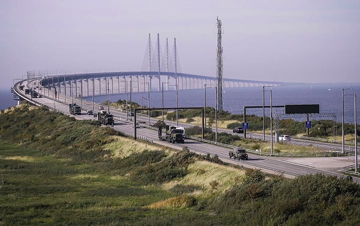  Un convoi de l’armée de terre britannique traverse le pont Øresund, qui relie le Danemark à la Suède, lors d’un déplacement de 2 000 km effectué entre Hoek van Holland et la Norvège dans le cadre de l’exercice Trident Juncture 2018 de l’OTAN. Un aspect important de cet exercice a consisté à démontrer la capacité de déplacer rapidement des forces alliées depuis l’extérieur et à l’intérieur de l’Europe, puis d’assurer leur maintien en puissance. © OTAN
