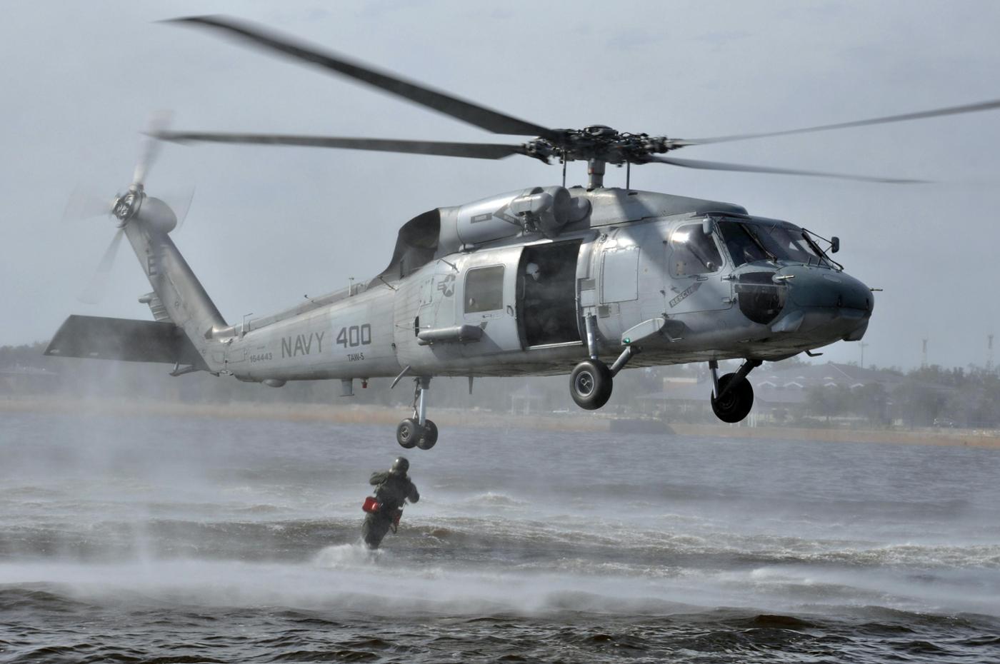 A search and rescue swimmer jumps from a US Navy SH-60F Sea Hawk helicopter. © US Navy
)