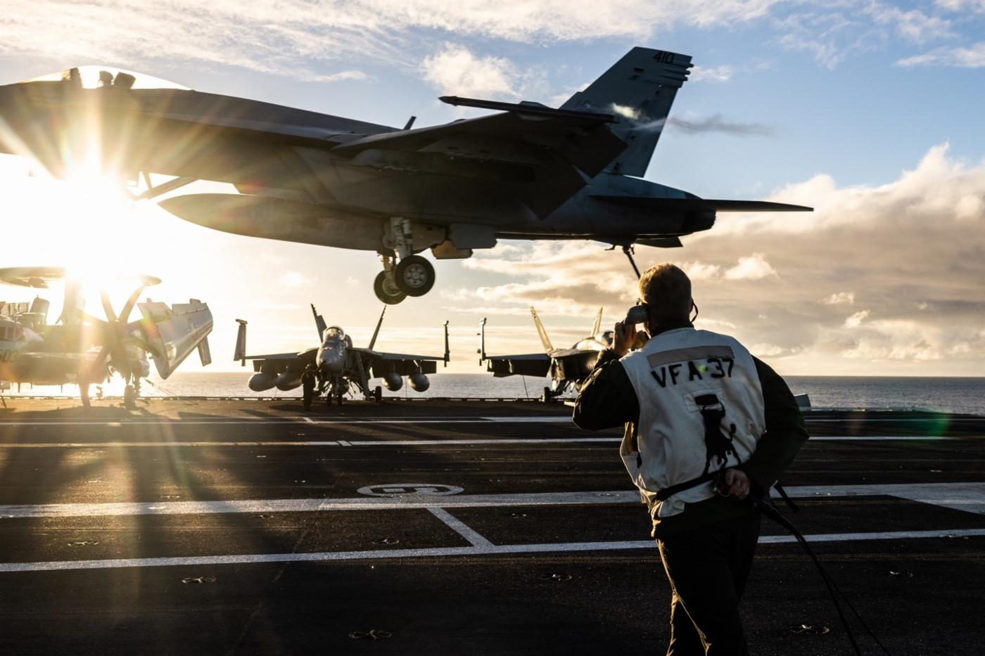 Lieutenant Commander William Craven, Landing Signal Officer for Naval Strike Fighter Squadron 37, guides an F/A-18E Super Hornet in for landing on the USS Gerald R. Ford.
)