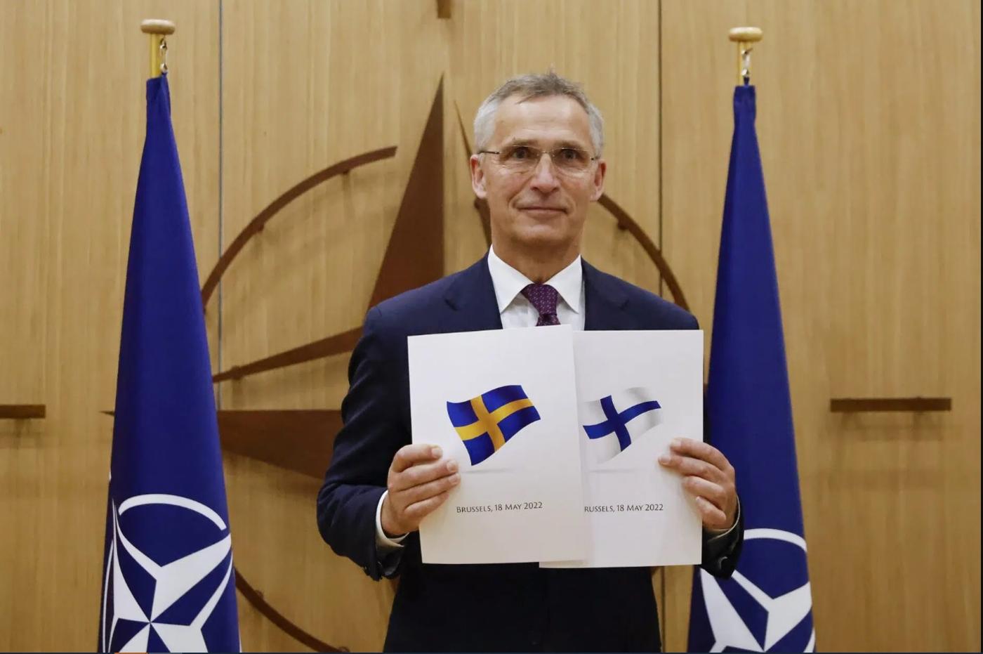 Le secrétaire général de l'OTAN, Jens Stoltenberg, arbore les demandes d’adhésion à l'OTAN que la Finlande et la Suède ont déposées le 18 mai 2022 à Bruxelles (Belgique). © Johanna Geron, Pool via AP
)