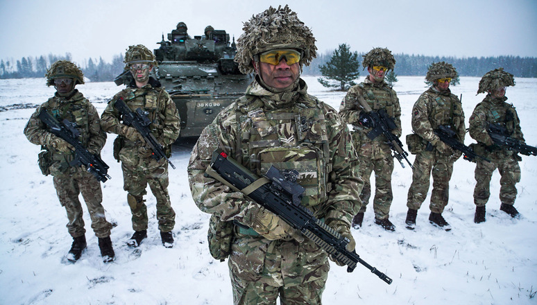 Corporal Lalabalavu from the Royal Welsh Regiment stands in front of his squad after exiting from a Warrior armoured fighting vehicle during an exercise near Tapa in Estonia. These troops form part of NATO's Enhanced Forward Presence battlegroup.