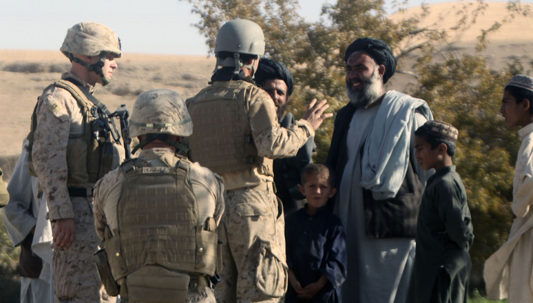 Marines from 9th Engineer Support Battalion, 1st Marine Logistics Group (Forward), talk to a local Afghans about demolishing a wall while Marines conduct road improvement operations adjacent to the wall in Sangin, Helmand province, Afghanistan. The Marines of 9th ESB, 1st MLG (FWD), improved roads near Sangin in order to provide a smoother and safer means of transportation for both coalition forces and Afghan villagers. 