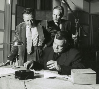 Orson Welles (seated) flanked by director Peter Baylis (left) and NATO Information Service Head, Peter Pooley (right).