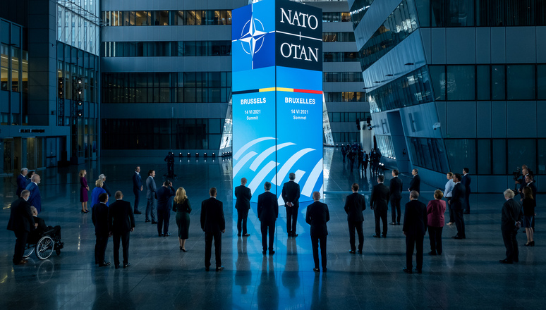 NATO Leaders take part in a welcome ceremony featuring a multimedia tower display. The display shows visualisations illustrating NATO's future adaptation through the NATO 2030 agenda. 