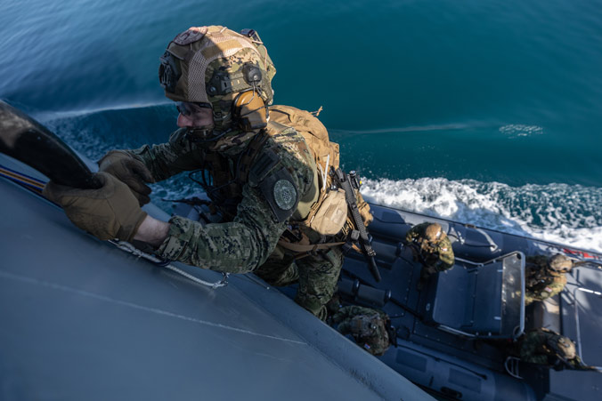 Un soldat des forces spéciales croates escalade le flanc du navire au moyen d'une échelle spéléo lors d'un exercice de reconnaissance, de visite, de perquisition et de saisie près de Split (Croatie).