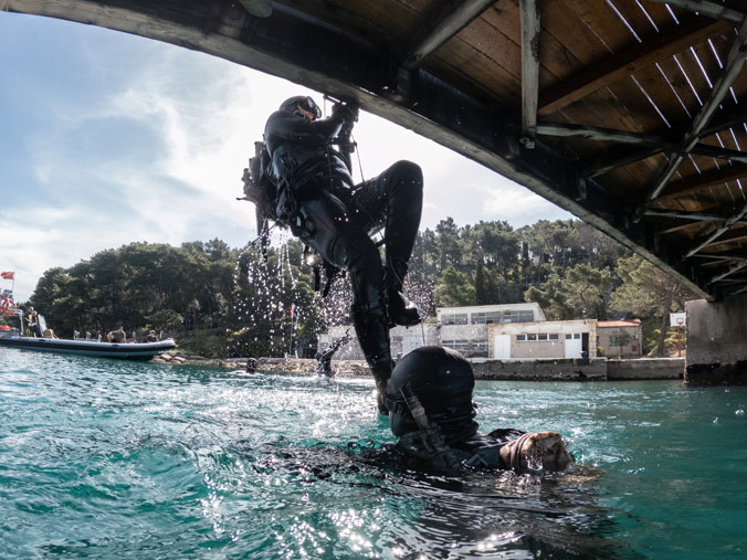 US Navy SEALs ascend a caving ladder attached  to a bridge during an exercise near Split, Croatia.