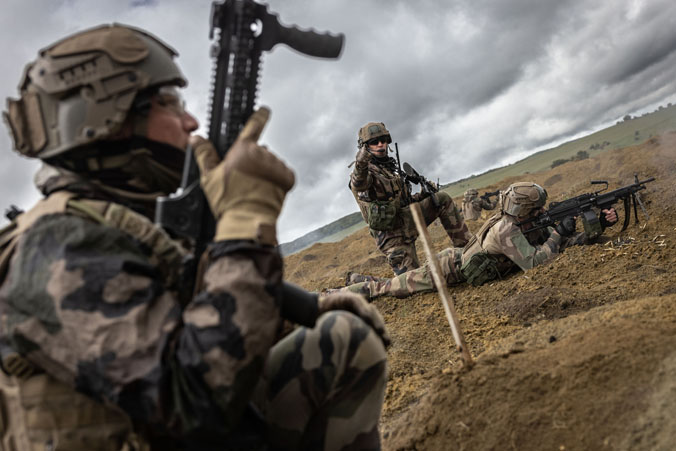 Des soldats français prennent position sous un ciel gris et nuageux pendant un exercice de tir réel à Cincu (Roumanie).