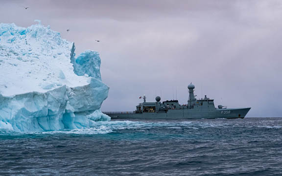 The Royal Danish Navy frigate HDMS Triton passes an iceberg in the waters around Greenland.