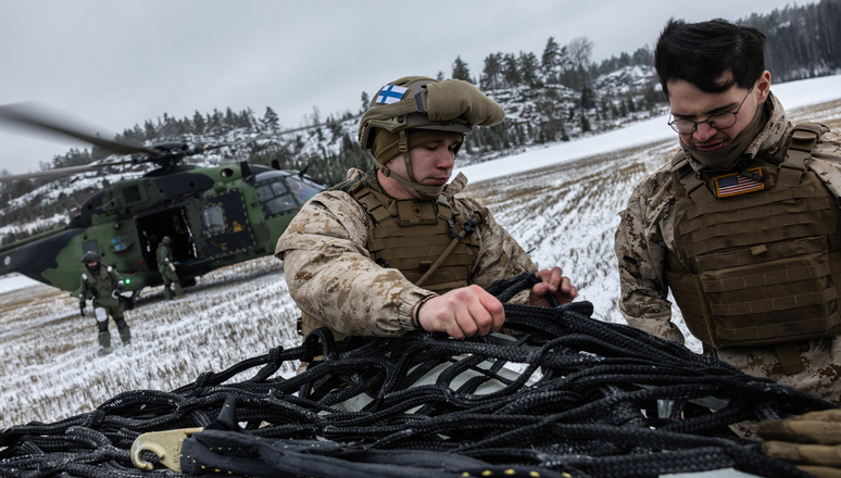 US Marines and Finnish Navy forces prepare a bulk container for sling transport via a Finnish Navy NH90 helicopter in southern Finland.