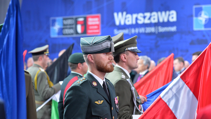 Allied armed forces carry their national flags in a ceremony honouring NATO military personnel in operational theatres before Heads of State and Government at the 2016 Warsaw Summit.