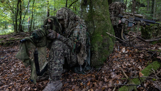 Latvian and German snipers conceal themselves with ghillie suits during the 2023 European Best Sniper Team Competition.