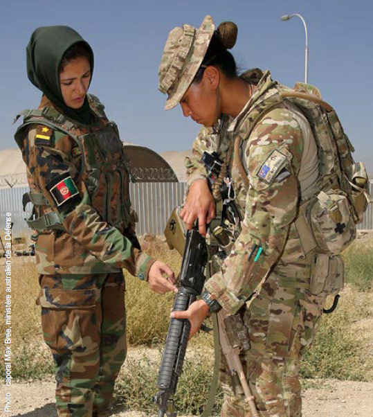 Empowering women: an Afghan officer trains
        with an Australian mentor in Kabul.